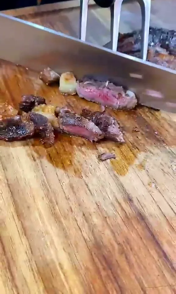 Carne no ponto sendo fatiada na tábua